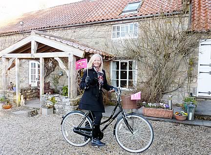 US TV host and travel writer Karen Schaler flies the flag for Yorkshire and the Grand Départ, as she prepares for her bike ride after an overnight stay at Carr House Farm.